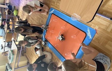 Grupa uczni&oacute;w z Szkoły Podstawowej w Nożynie prezentuje wykonane przez siebie roboty. 