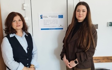 Dwie kobiety stoją obok siebie przy drzwiach; po lewej Dyrektor Centrum Usług Społecznych Pani Jolanta Bork, po prawej prowadząca warsztaty pn.: ,,Czasem nuda jest potrzebna&rsquo;&rsquo; Pani Alicja Iciek. Na drzwiach widnieje plakat wskazujący na realizację projekt