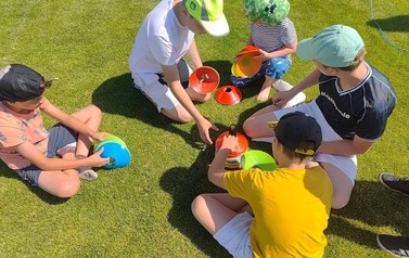 Na zdjęciu dzieci przygotowują się do konkurencji sportowej polegającej na rzucaniu do celu.