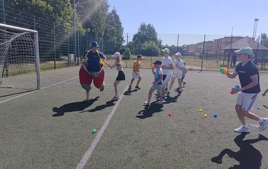 Na zdjęciu dzieci uczestniczące w zabawach sportowych na Orliku, rzucające piłkami.